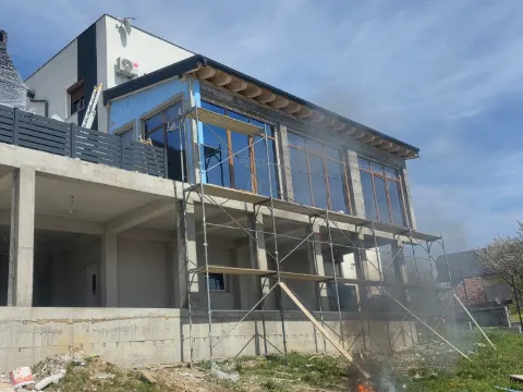 Kuća na sprat u izgradnji, sa skelom i novim prozorima